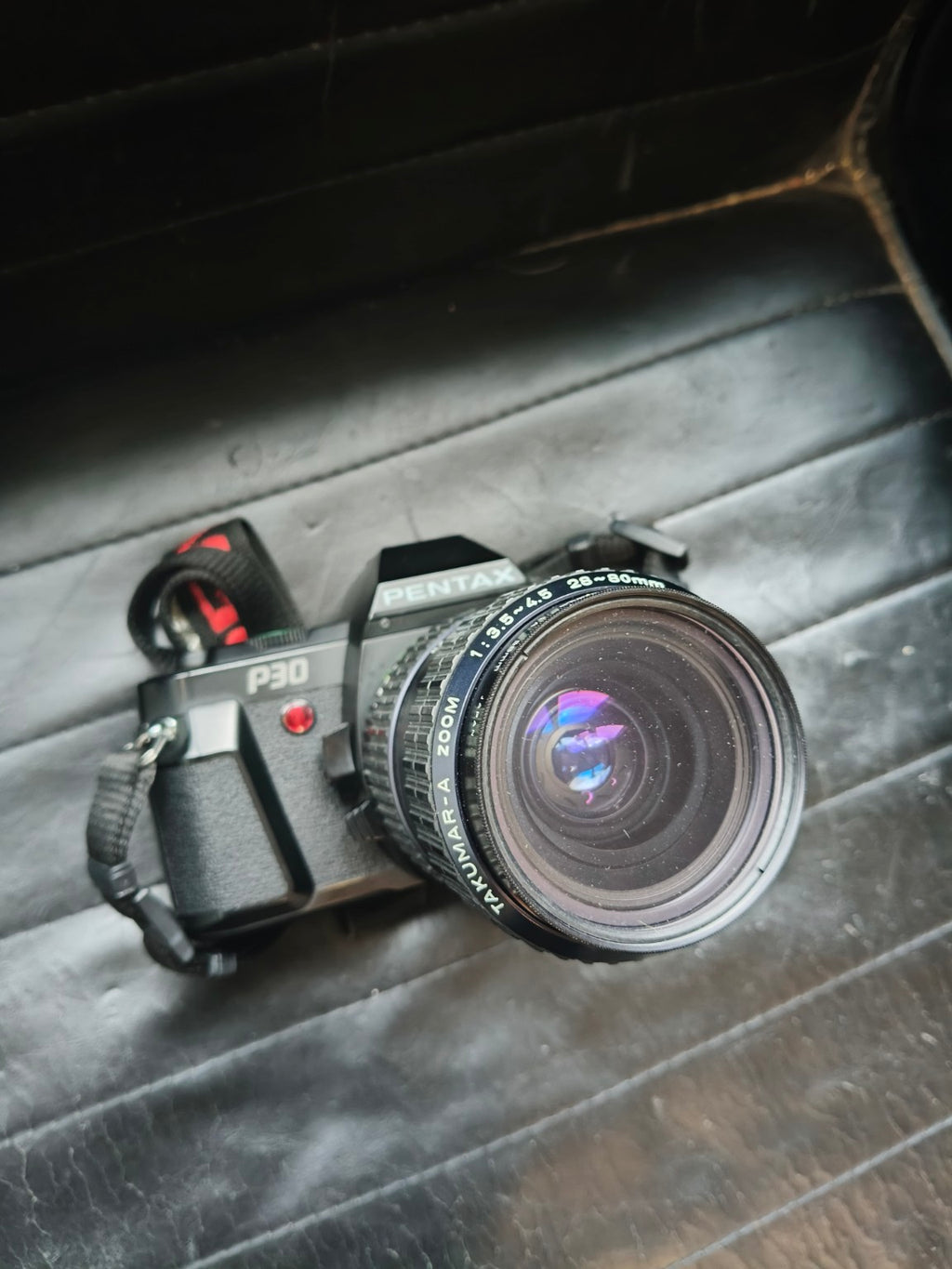 Pentax P30 met lens en draagriem