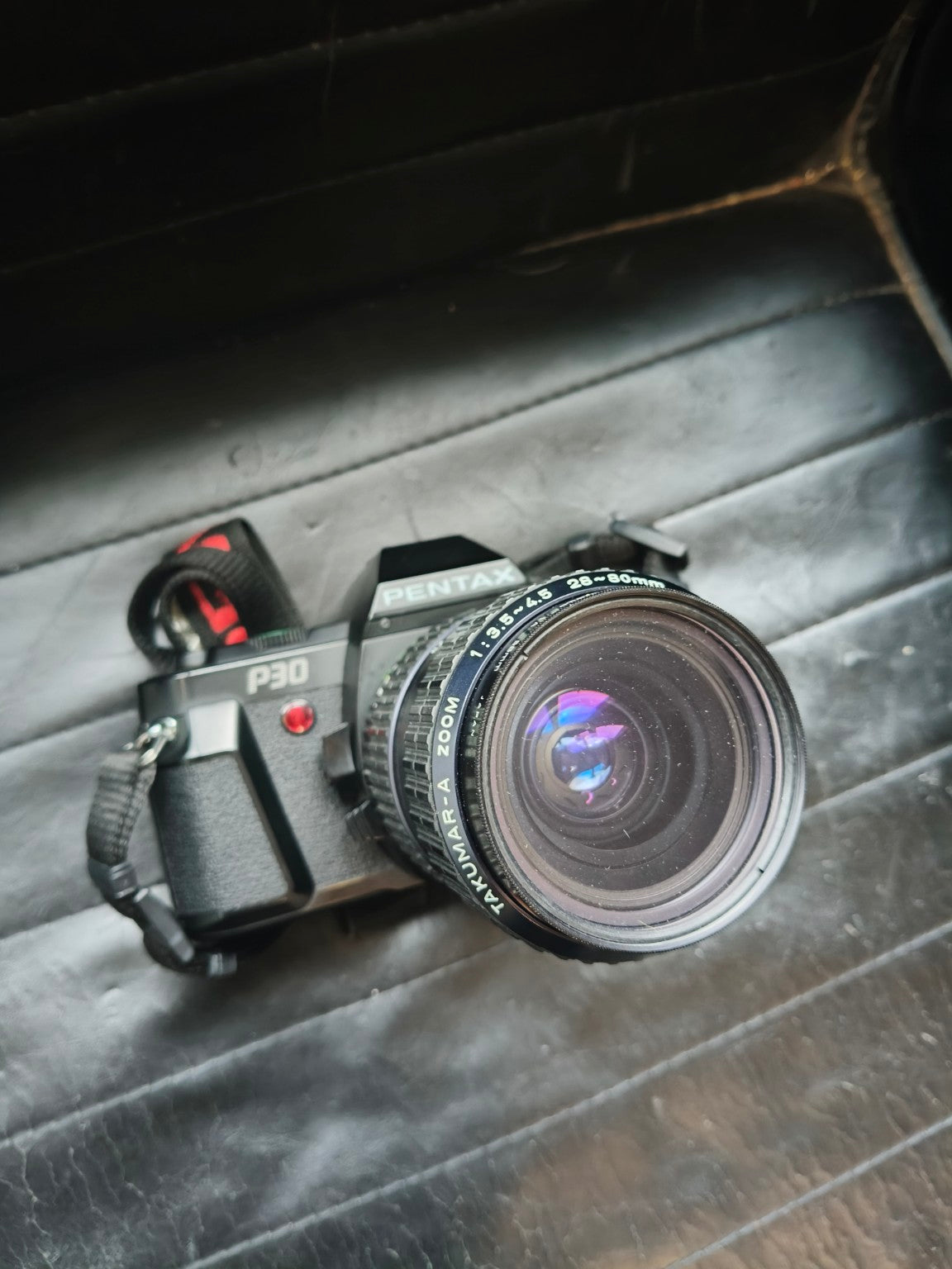 Pentax P30 met lens en draagriem