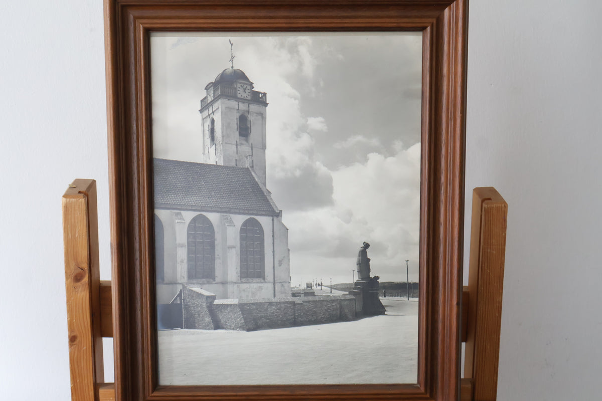 Ingelijste zwart-witfoto van kerk en standbeeld