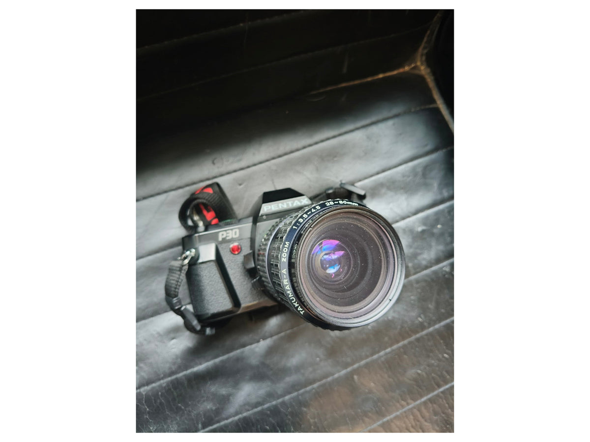 Pentax P30 met lens en draagriem