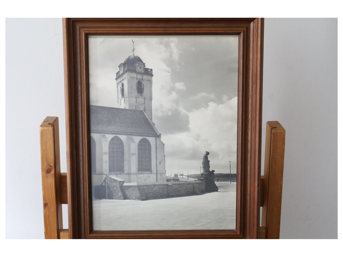 Ingelijste zwart-witfoto van kerk en standbeeld