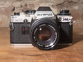 Olympus OM-10 analoge 35mm spiegelreflexcamera met Zuiko 50mm f/1.8 – vintage analoge camera bij De Majum Rotterdam
